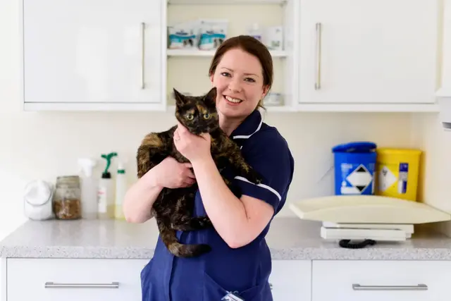 Morven holding a black and brown cat