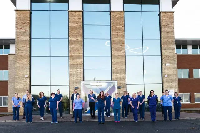 team standing outside VSS building in uniform