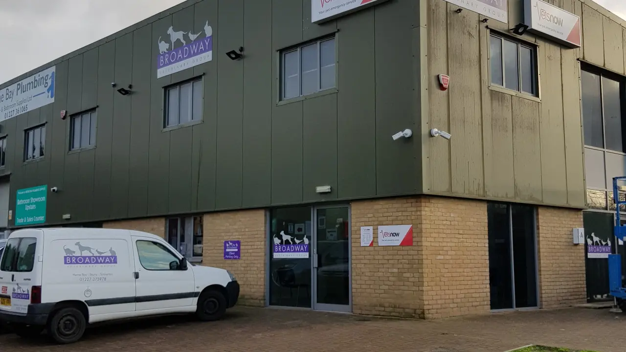 A veterinary office building displays signs reading