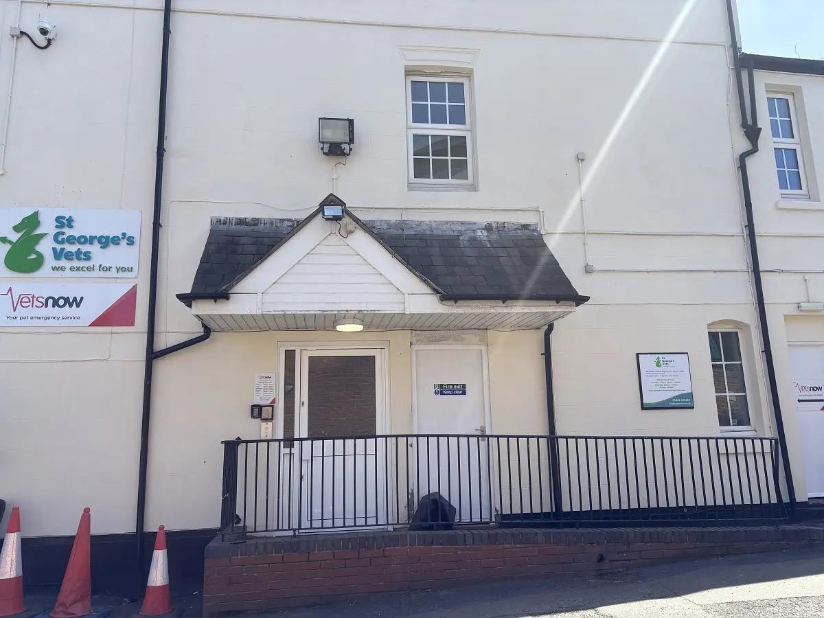 Wide view of St George’s Vets in Wolverhampton rear building with entrance ramp, multiple signs including Vets Now branding, and white exterior walls.